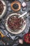Healthy Black beluga lentil salad with pomegranate in metal plate with cutlery on dark rustic background with cooking ingredients