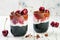 Healthy Black Forest dessert. Black activated charcoal chia pudding with cherries, coconut cream and chocolate. Vegan breakfast