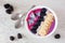 Healthy blackberry smoothie bowl, top view on a white marble background