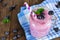 Healthy blueberry smoothie in a mason jar, downward view with cloth against rustic wood