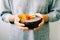 Healthy breackfast in bowl of coconut with nasturtium flowers in hands on white background