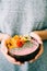 Healthy breackfast in bowl of coconut with nasturtium flowers in hands on white background