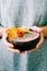 Healthy breackfast in bowl of coconut with nasturtium flowers in hands on white background