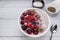 Healthy breakfast berry smoothie bowl topped with Blueberries, blackberries, chia seeds, raspberry and grounded coconut flakes.