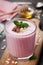 Healthy breakfast of berry smoothie or milkshake with oats and honey decorated mint leaves and grated chocolate