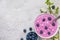 Healthy breakfast bowl: blueberry acai smoothie with cottage cheese, chia seeds and spring blossoming flowers. top view