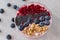 Healthy breakfast bowl: blueberry smoothie with banana, raspberry, blackberry, nuts on table