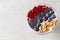 Healthy breakfast bowl: blueberry smoothie with banana, raspberry, blackberry, nuts on white  table