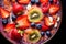 Healthy breakfast bowl with fresh berries - strawberries, blueberries, kiwi and almonds, balanced diet nutrient-rich, close-up