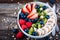 Healthy breakfast bowl granola with raspberries, strawberries, blueberries, banana, kiwi and chia seeds
