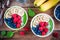 Healthy breakfast bowl: green spinach smoothie with banana, blueberries, raspberries, chia seeds and coconut