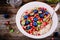Healthy breakfast bowl porridge with fresh blueberries, pomegranate, mint, chia, flax and pumpkin seeds