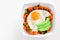 Healthy breakfast bowl with sweet potato, egg, avocado and spinach over white wood