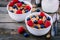 A healthy breakfast bowl. Whole grain cereal with fresh blueberries and raspberries on wooden background.