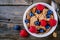 A healthy breakfast bowl. Whole grain cereal with fresh blueberries and raspberries on wooden background. Top view
