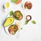 Healthy breakfast: cereal rolls with salmon, cherry tomatoes, spinach, avocado. blueberry on a light background. Top