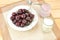 Healthy of breakfast compose of a plate of cherry, a glass of milk and a jar of yogurt on the cloth with wooden background