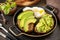 Healthy breakfast concept, sandwich with avocado and egg. Wholemeal bread toast sliced avocado and poached egg on a stone