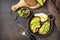 Healthy breakfast concept, sandwich with avocado and egg. Wholemeal bread toast sliced avocado and poached egg on a stone