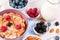 Healthy breakfast with cornflakes berries, milk and almond nuts on wooden table