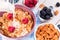 Healthy breakfast with cornflakes berries, milk and almond nuts on wooden table