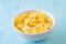 Healthy breakfast. Cornflakes in a white cup, standing against a blue background