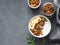 Healthy breakfast. Flat lay of homemade granola or muesli with banana and nuts in a bowl on a dark background