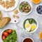 Healthy breakfast with fried eggs, fresh bread, salad, berries, tomatoes, nuts, beverage cup, arugula, mushrooms on a