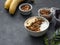 Healthy breakfast. Homemade granola with banana and nuts in a bowl on a dark background close up