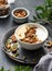 Healthy breakfast. Homemade granola or muesli with banana and nuts in a bowl on a dark background with branch