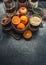 Healthy breakfast ingredients. Nuts and cereals in glasses for granola and fruits on dark rustic kitchen table, top view. Copy