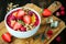 Healthy breakfast. Mango maca smoothie bowl topped with hazelnuts, oat granola, fresh berries and raspberry puree.