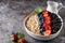Healthy breakfast, muesli with currants, blueberries and strawberries in bawl on dark backgrund