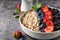 Healthy breakfast, muesli with currants, blueberries and strawberries in bawl on dark backgrund
