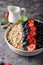 Healthy breakfast, muesli with currants, blueberries and strawberries in bawl on dark backgrund