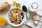 Healthy breakfast with muesli, grapes, cheese and juice on rustic white table from above.