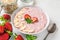 Healthy breakfast. overnight oats with fresh strawberries, almonds and mint in a bowl with a spoon