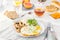 Healthy breakfast plate with scrambled eggs, cheese, grilled mushrooms and sprout micro greens and other snacks and drinks on the