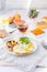 Healthy breakfast plate with scrambled eggs, cheese, grilled mushrooms and sprout micro greens and other snacks and drinks on the