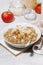 Healthy breakfast quinoa with apple and coconut on white table, vertical