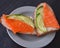 Healthy breakfast. sandwich with salmon and cucumber, brown bread and butter on a wooden background