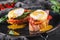 Healthy breakfast sandwiches. Bread toasts with Poached eggs or eggs Benedict, fresh vegetables, avocado, fillet salmon