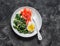 Healthy breakfast, snack - boiled egg, braised spinach, smoked salmon on a dark background, top view