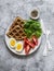 Healthy breakfast, snack - savory waffles, boiled egg, fresh tomatoes, lettuce on a gray background, top view