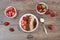 Healthy breakfast -yoghurt with oat flakes, raisins, strawberries, muesli. Fruit breakfast on a wooden background