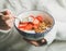 Healthy breakfast yogurt, granola, strawberry bowl in woman`s hands