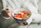 Healthy breakfast yogurt, granola, strawberry bowl in woman`s hands