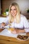 Healthy breakfast - young cheerful woman eating corn flakes with milk in kitchen