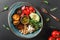 Healthy Buddha bowl dish with avocado, tomato, cheese, chickpea, fresh arugula salad, baked potatoes and sauce pesto on background