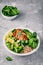 Healthy buddha bowl lunch with grilled chicken, quinoa, spinach, avocado, brussels sprouts, broccoli, cucumbers with sesame seeds